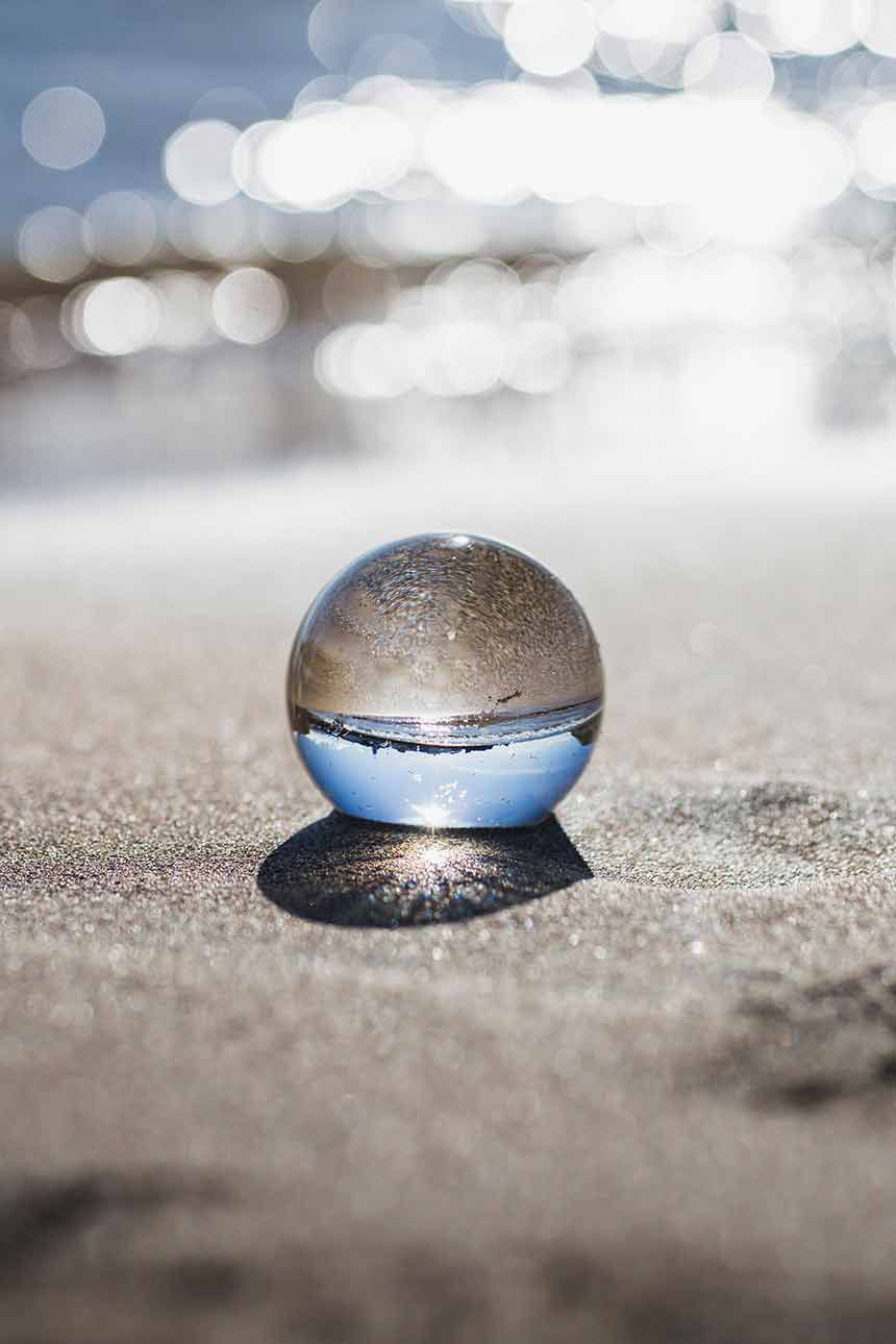 Glaskugel am Strand mit strahlendem Sonnenschein